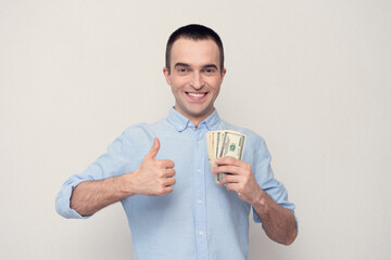 Man with the cash shows sign super with thumb up, a white background, copy space