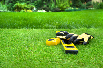 An artificial grass background. Tools on the artificial turf lawn.