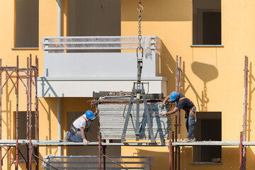 Workers at Work on a Scaffold in a Building Site for the Construction of a Building