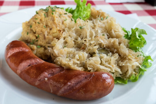 Traditional dish in Slovenia - kranjska klobasa (pork sausage) with mashed pe puree and stewed cabbage