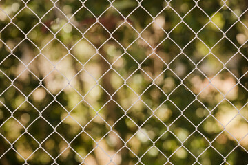 Field steel grid fence, metal fence wire with grass in the background.