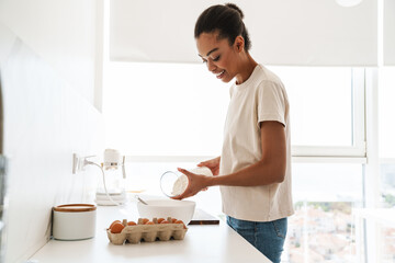 Positive woman cooking at the kitchen at home