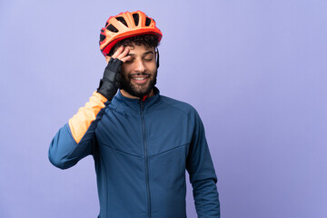 Young Moroccan cyclist man isolated on purple background smiling a lot