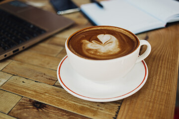 Cup of hot coffee on table