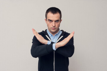 Man shows a stop sign with his arms crossed, white background