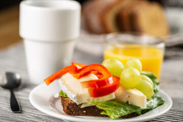 Hotel breakfast with coffee, sandwich with brie and grape and orange juice