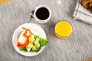 Hotel breakfast with coffee, sandwich with brie and grape and orange juice