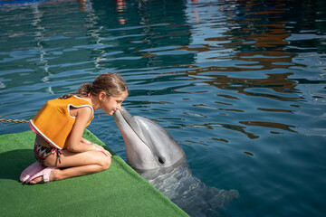 a kid girl playing with a dolphin © Emre
