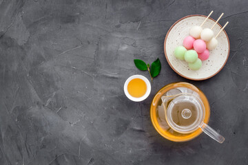 Japanese food background with sweets and tea. Three colored dumplings Dango