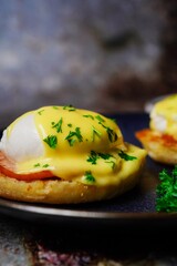 Homemade  Egg Benedict with perfect poached eggs Canadian bacon topped with Hollandaise sauce, selective focus