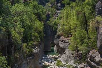 Fototapeta na wymiar Creek eroded rocks. Flowing stream between rocks. Antalya Koprulu Canyon. Turkey, august 2020