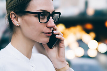 Serious businesswoman talking on smartphone in street