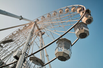 Low angle view of a ferris wheel against a  clear blue sky