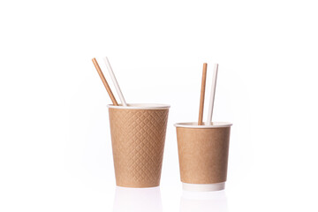 Two disposable brown paper cups small and medium sizes with straws isolated on white background. Coffee to go, takeaway hot drinks, cafe, eco-friendly tableware concept, mockup template. Copy space