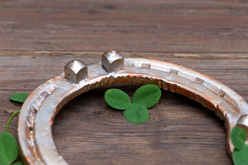 clover leaves and golden horseshoe on vintage wooden boards. Good luck symbol, St. Patrick's Day and New Year concept.