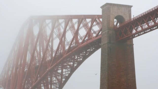 Close-up view of the Forth Bridge enshrouded in mist seen from North Queensferry, a cantilever railway bridge across the Firth of Forth and a symbol of Scotland, UK