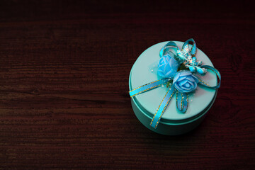 Metal gift box with flower decoration isolated on wooden table	

