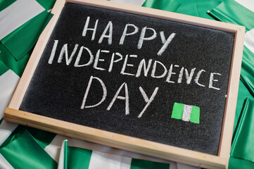 Happy independence day of Nigeria. Text on board with nigerian flags.