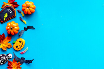 Halloween decoration concept with pumpkins, cookies and autumn leaves, top view