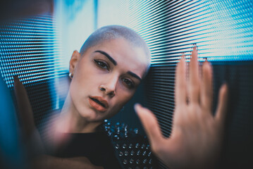 Image of a beautiful young woman posing against a led panel.