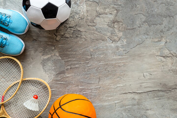 Sport games equipment - balls, sneakers, rackets - on grey top view copy space