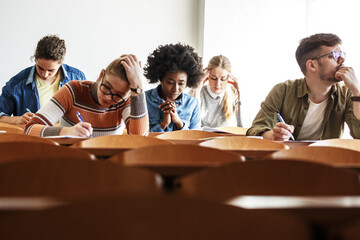 Group of college students working on  test in a classroom. Educational concept.	
