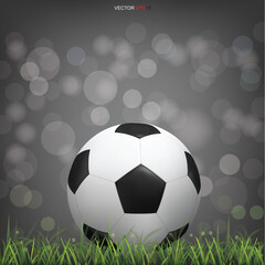 Obraz premium Soccer football ball on green grass field with light blurred bokeh background. Vector.