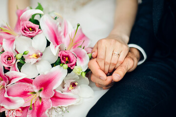 Obraz na płótnie Canvas hands of the bride with a bouquet