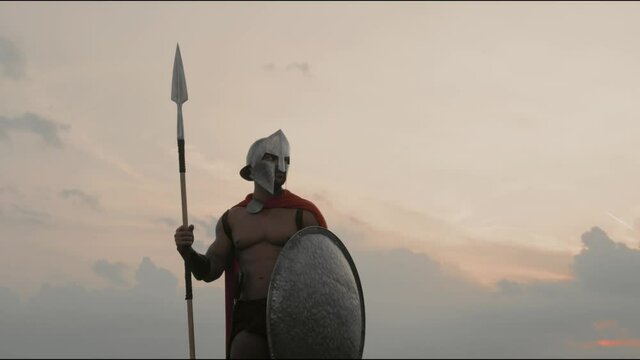 Spartan holding spear outdoors.