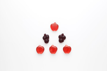 Chewy fruit marmalade with natural juice and pectin is laid out in triangle shape on a light background. Flat lay, top view, copy space