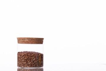 corked glass jar with uncooked buckwheat. Concept of healthy nutrition, diet, vegetarian products. isolated on white background copy space