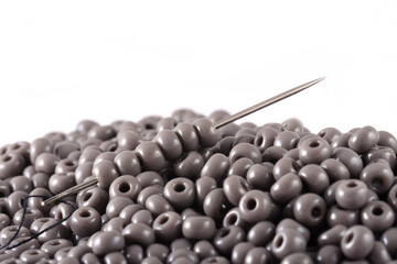 Beads spread on white background with needle. Beads with needle . Close up, macro,It is used in finishing fashion clothes. make bead necklace, beads for woman of fashion,Bead Crochet. Daily Beading.