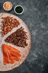 Homemade shawarma, burrito, chicken and salmon roll with vegetables and sauce. Top view ingredients with clear space.