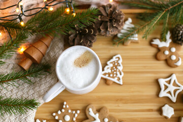 Christmas  gingerbread cookies, coffee, pine cones, fir branches and warm lights on wooden table