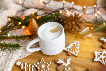 Christmas  gingerbread cookies, coffee, pine cones, fir branches and warm lights on wooden table