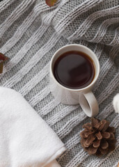 Obraz na płótnie Canvas Cozy home decor with a warm atmosphere. White mug with hot tea and knitted clothes