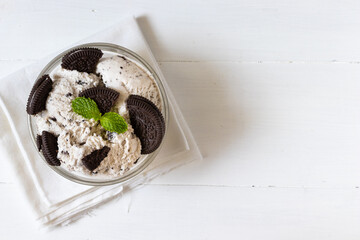 Chocolate cookie and ice cream in a glass bowl with mint leaf on white wooden background, summer sweet and dessert