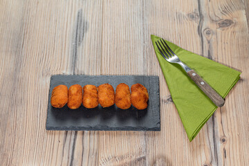 Fried Spanish ham Croquettes over a wooden background