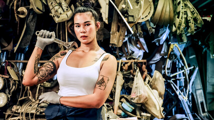 Attractive young woman mechanical worker repairing a vintage car in old garage..