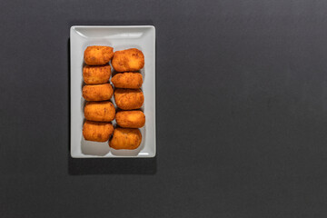 Fried Spanish ham Croquettes over a black background