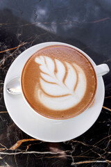 Big cappuccino cup on cafe table. Hot coffee on table. Vertical photo. Macro.