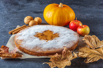 American homemade pumpkin or apple pie with walnut and autumn dry leaves on rustic table. Thanksgiving dish. Autumn harvest festival. Copy space for text