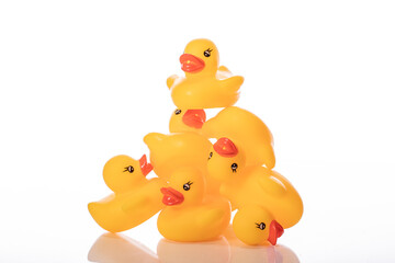 Rubber toy ducklings building pyramid isolated on white background. Minimal style. Aspiration, desire to reach new heights
