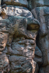 Large geometric stone rocks form of face profile in light of sun. Big cliff. Krasnoyarsk pillars, nature park in Siberia. Summer