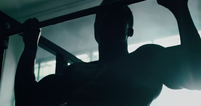 Cinematic slow motion shot of a professional young muscular shirtless african man is practicing shadow boxing work out in a gym with ring. 