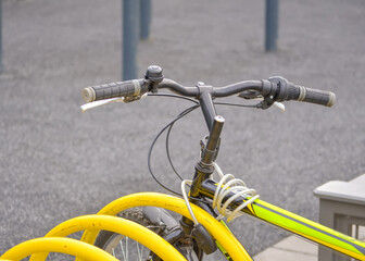 Fototapeta na wymiar Handlebar and frame of a sports bicycle strapped to a parking place close up