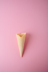 Empty waffle cone on a pink background close-up