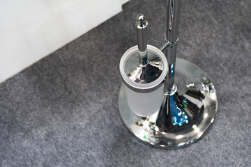 Modern chromed toilet brush. Toiletries in the interior. View from above