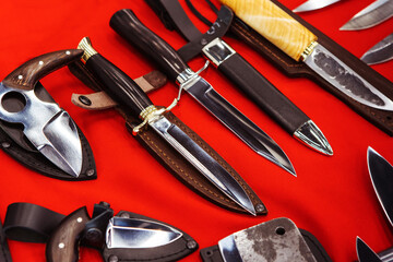 Combat knives on a red background. Arms trade in the store. View from above