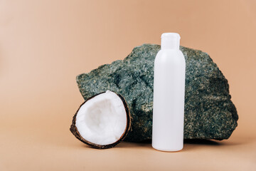 Coconut and a tube of cosmetics on a stone background